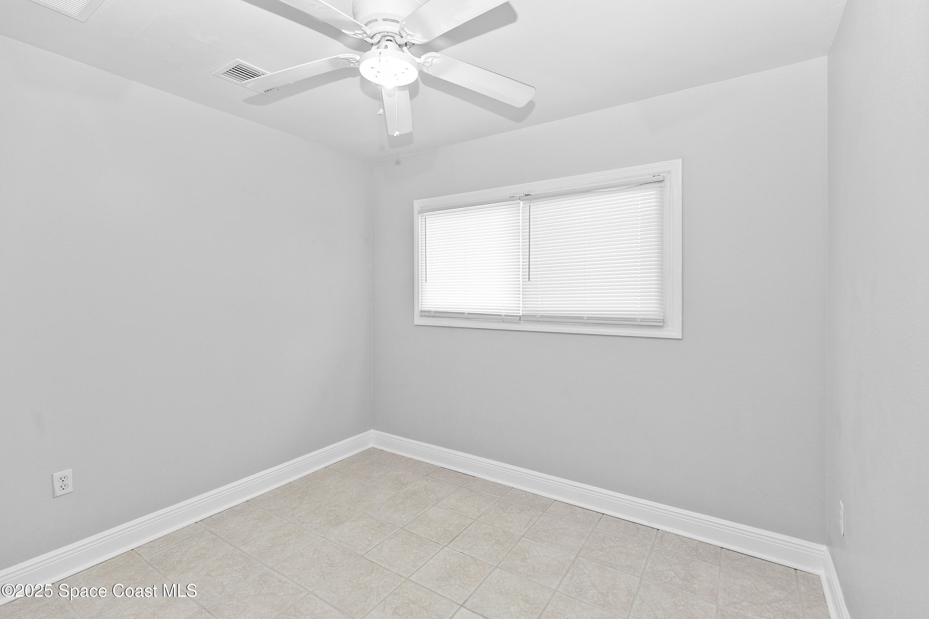 905 North Carpenter Road Titusville, FL 32796 - Photo 14 of 27 an empty room with a window and a fan