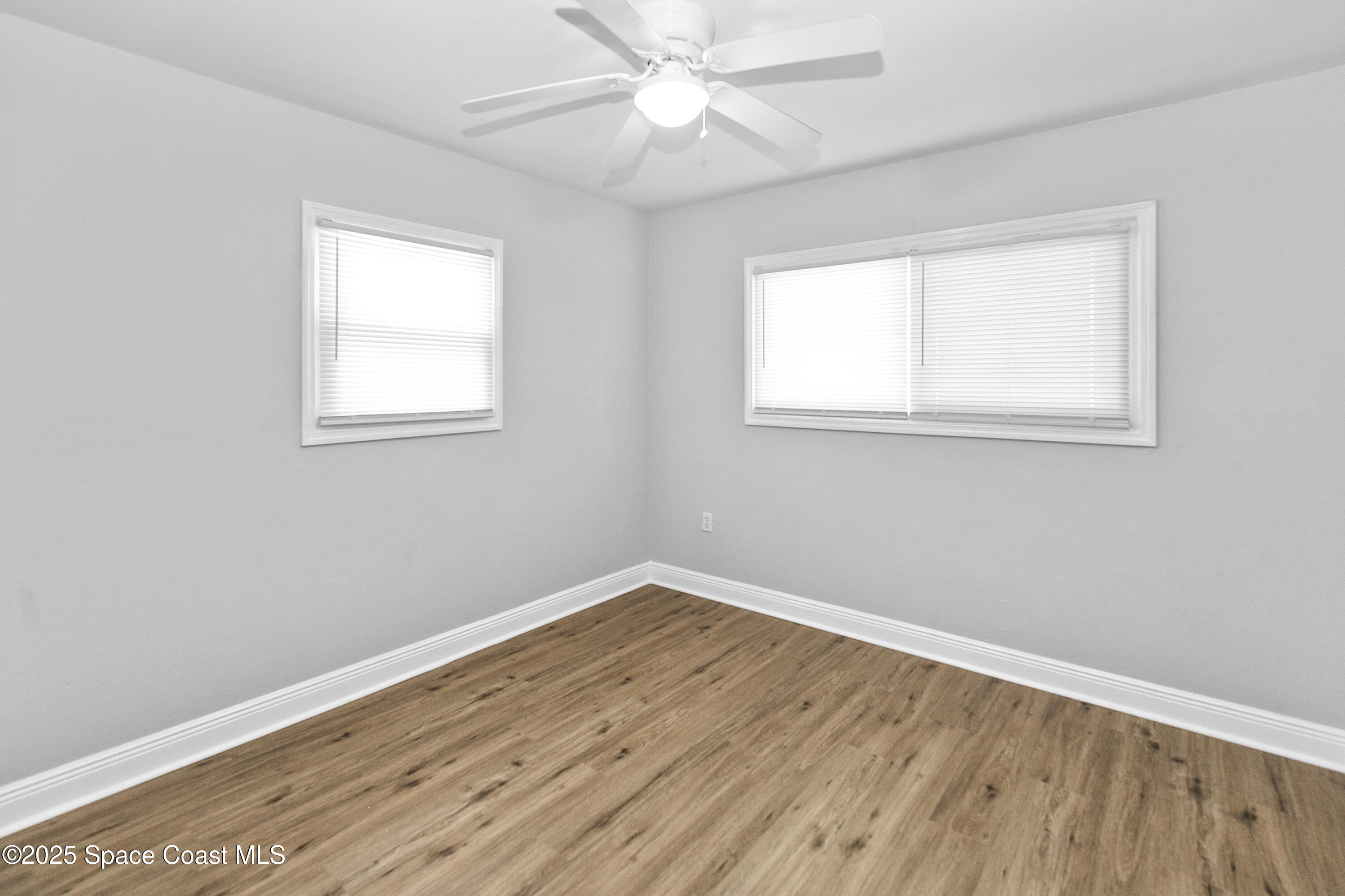 905 North Carpenter Road Titusville, FL 32796 - Photo 18 of 27 an empty room with a window and wooden floor