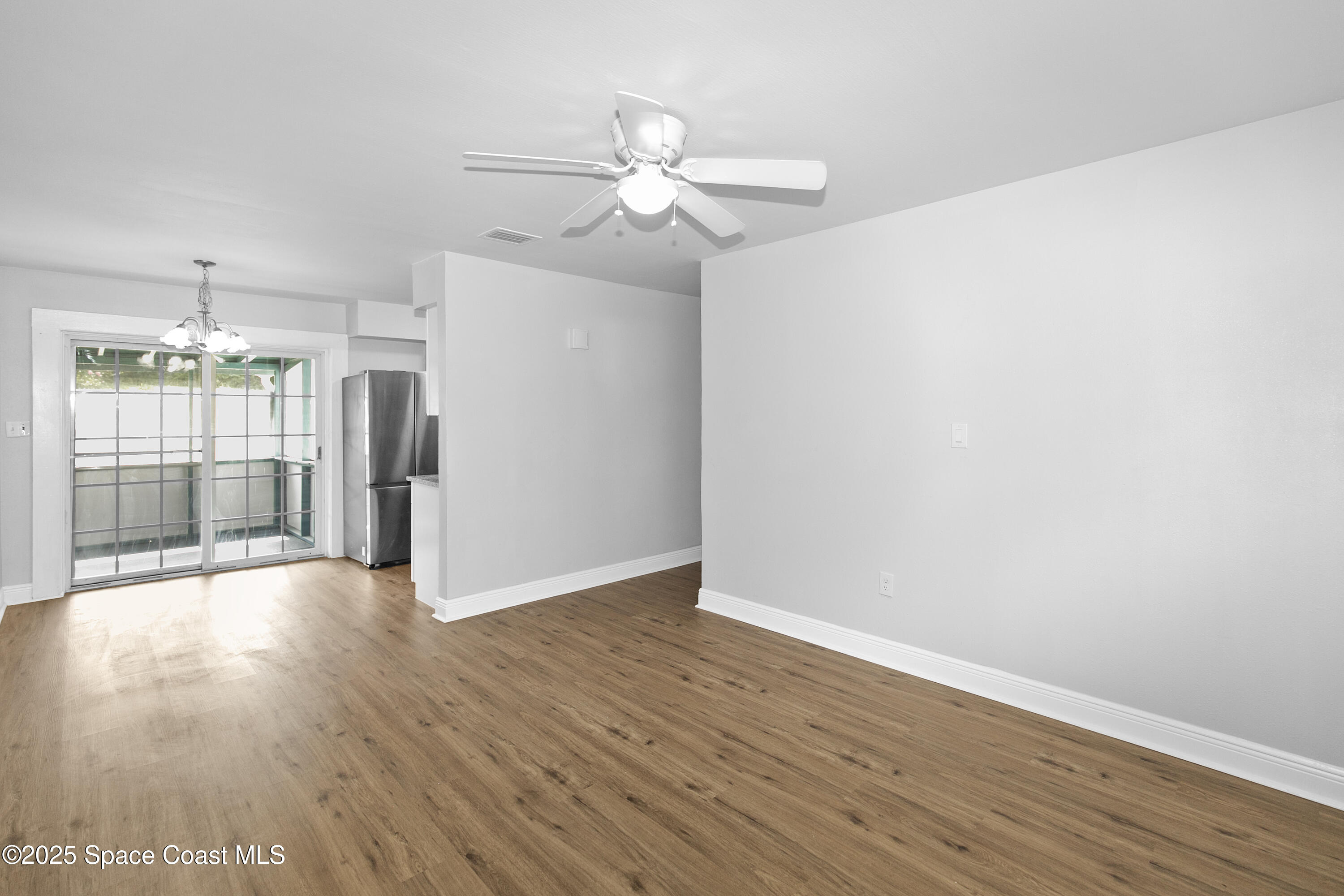 905 North Carpenter Road Titusville, FL 32796 - Photo 6 of 27 a view of an empty room with wooden floor and a window