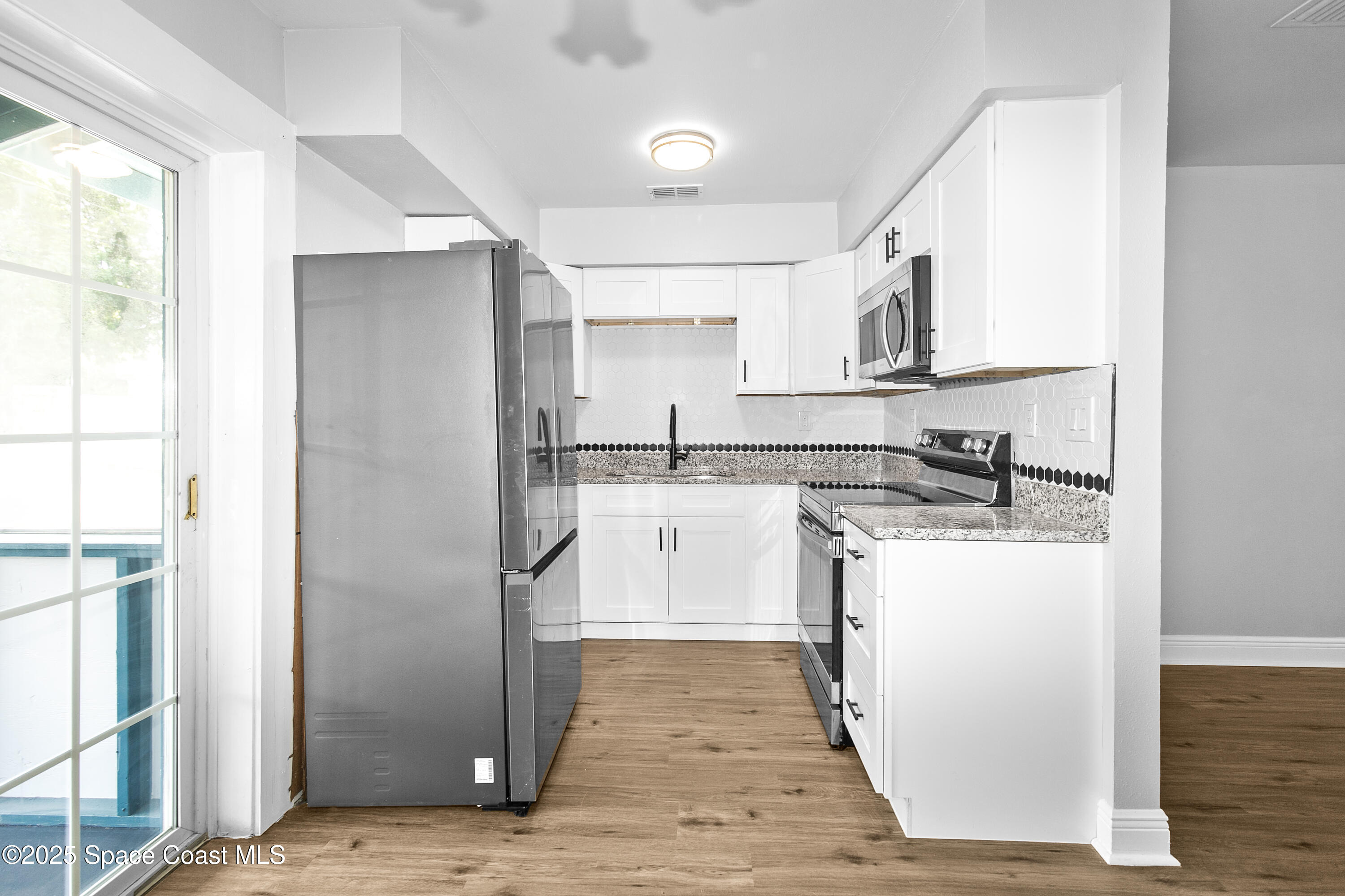 905 North Carpenter Road Titusville, FL 32796 - Photo 7 of 27 a kitchen with stainless steel appliances granite countertop a refrigerator and a stove