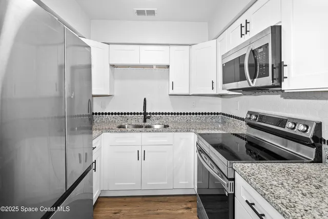 a kitchen with stainless steel appliances granite countertop a sink stove and microwave