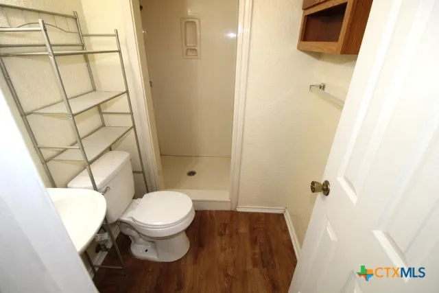 a bathroom with a toilet and a shower