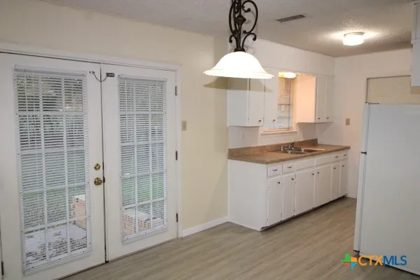 a kitchen with granite countertop a stove a sink and a chandelier