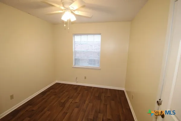 an empty room with a window and wooden floor