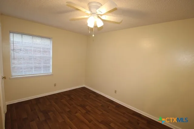 a view of a room with wooden floor and a window