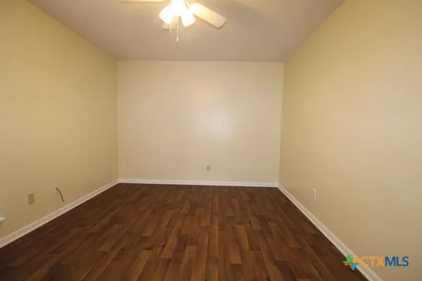 a view of a room with wooden floor and a window