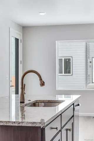 a kitchen with granite countertop a sink cabinets and stainless steel appliances
