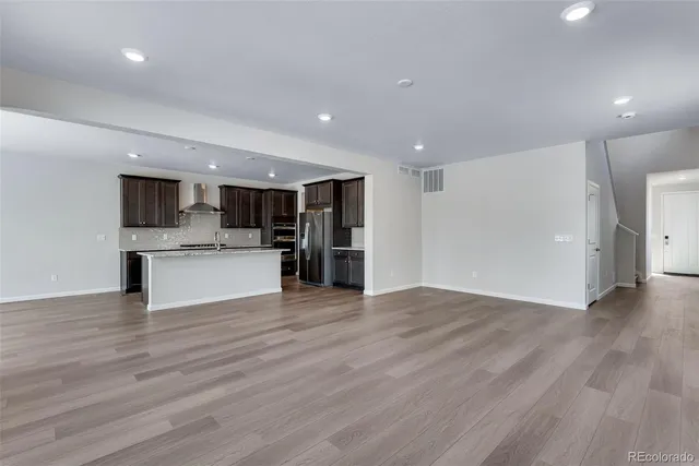 a kitchen with stainless steel appliances kitchen island wooden floors and white cabinets