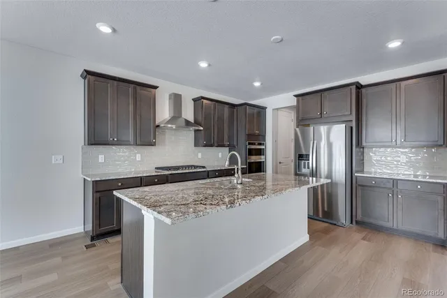 a kitchen with stainless steel appliances granite countertop a sink stove and cabinets