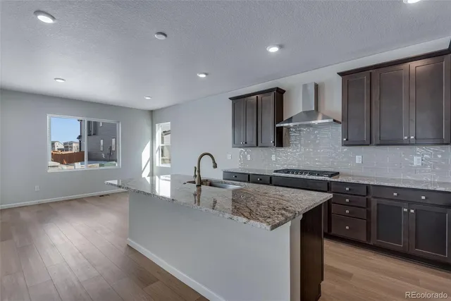 a kitchen with granite countertop cabinets a sink and wooden floor