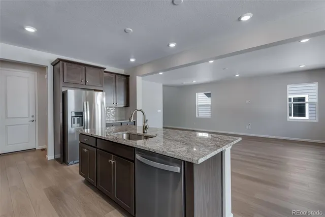 a kitchen with stainless steel appliances granite countertop a sink stove and cabinets