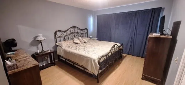 a bedroom with a bed and a mirror on dresser