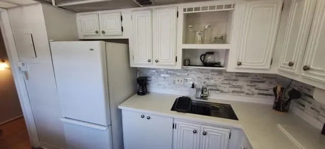 a kitchen with white cabinets and sink