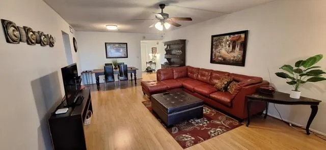 a living room with furniture a wooden floor and a chandelier