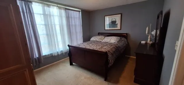 a bed sitting in a bedroom next to a window