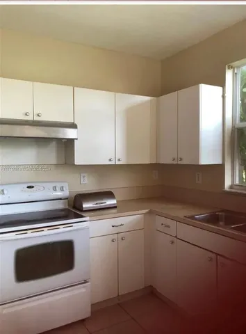 a kitchen with white cabinets appliances and a sink