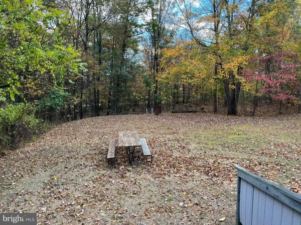 a view of an empty room with wooden floor and windows