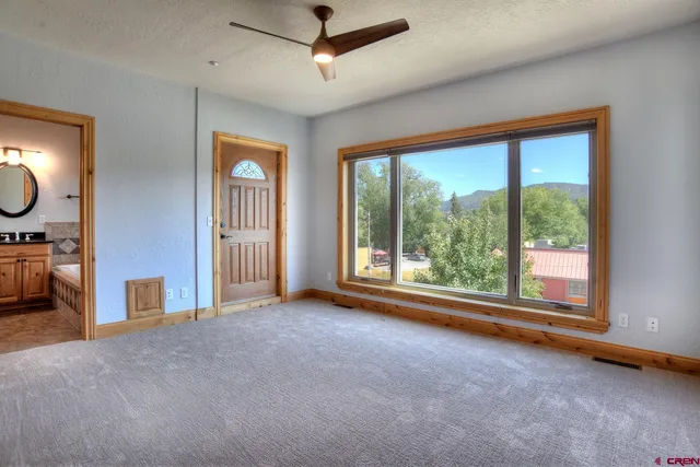 a view of a livingroom with furniture window ceiling fan and windows