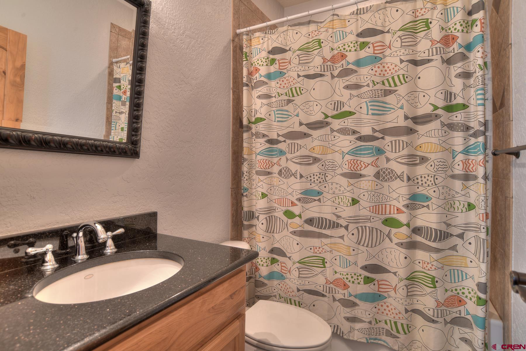 2855 Main Avenue, Unit A204 Durango, CO 81301 - Photo 29 of 45 a bathroom with a granite countertop sink toilet a mirror and shower curtain