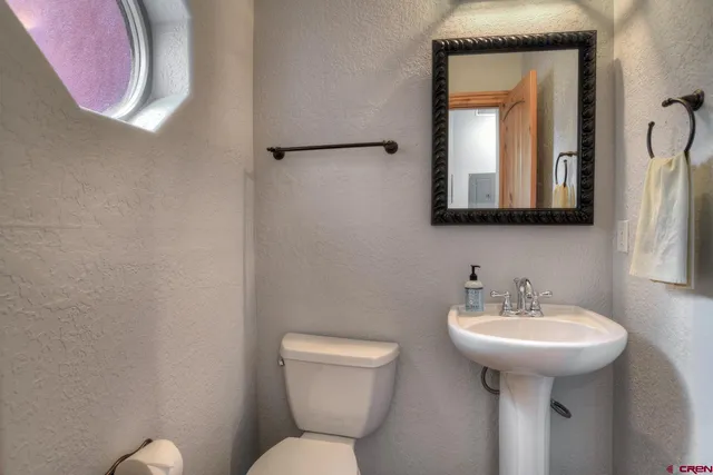 a bathroom with a toilet sink and mirror