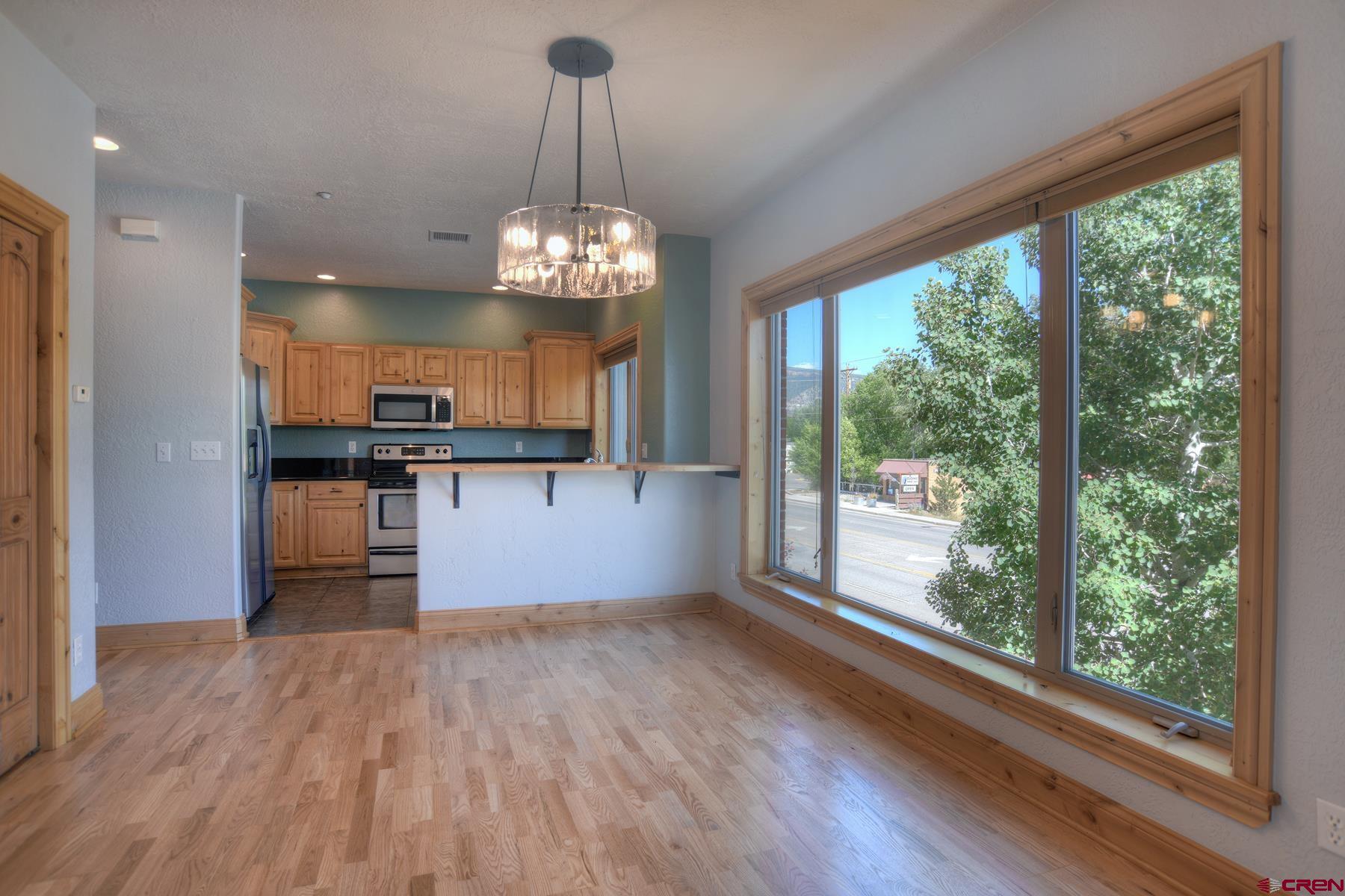 2855 Main Avenue, Unit A204 Durango, CO 81301 - Photo 5 of 45 a view of a kitchen with a stove wooden floor and a chandelier