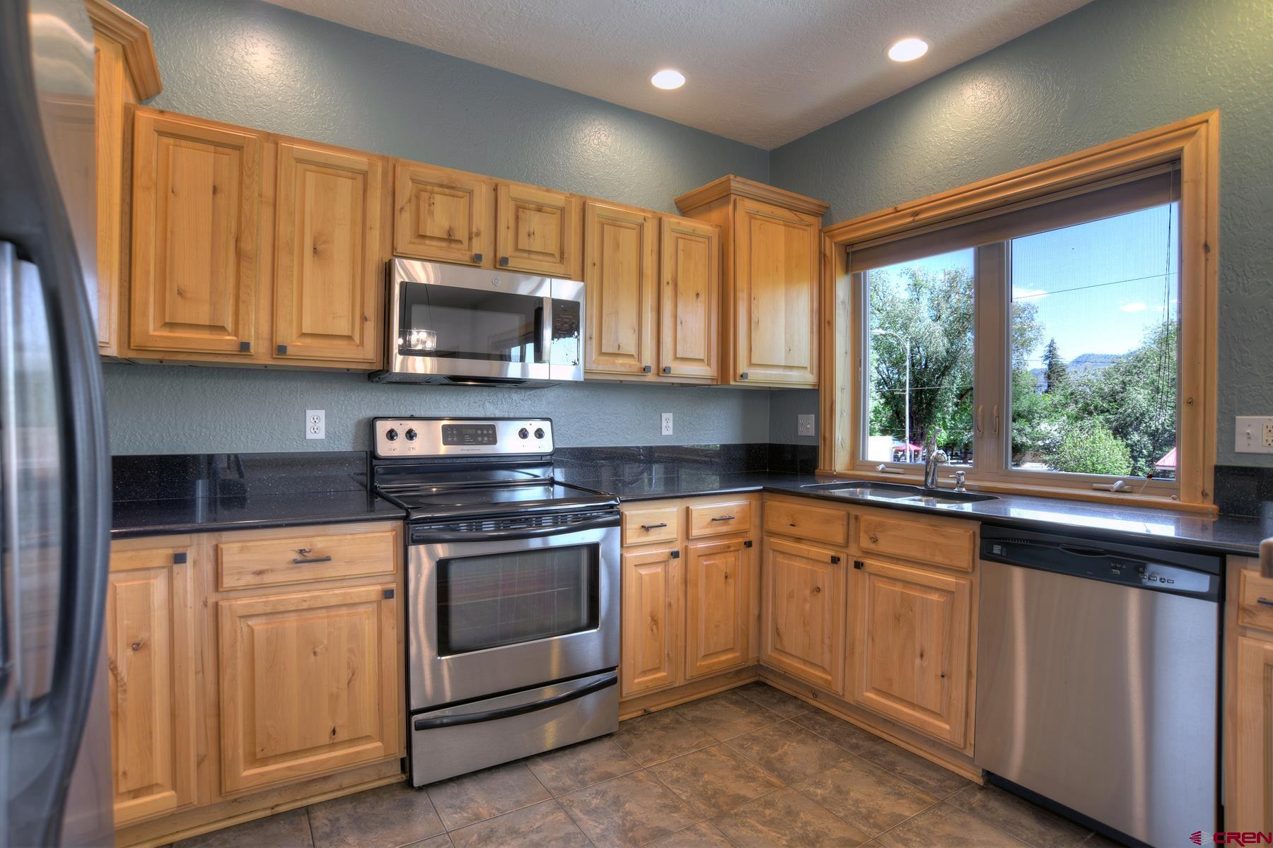 2855 Main Avenue, Unit A204 Durango, CO 81301 - Photo 10 of 45 a kitchen with granite countertop wood cabinets stainless steel appliances and a window