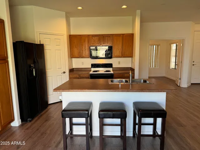 a kitchen with stainless steel appliances a dining table chairs and wooden floor