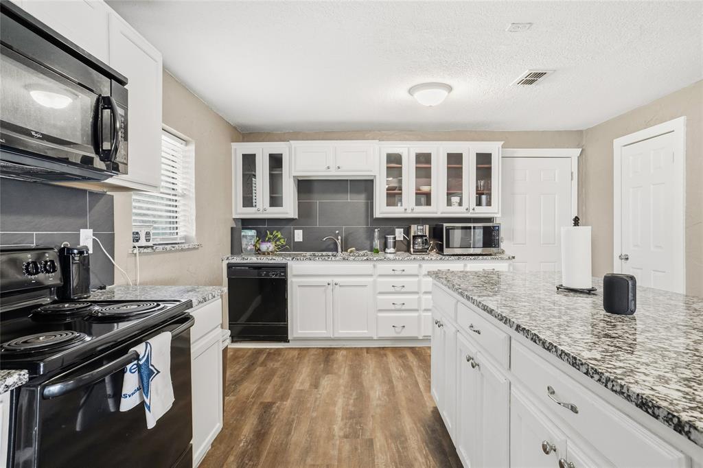 207 School House Road Paradise, TX 76073 - Photo 12 of 33 a kitchen with granite countertop a stove and a sink