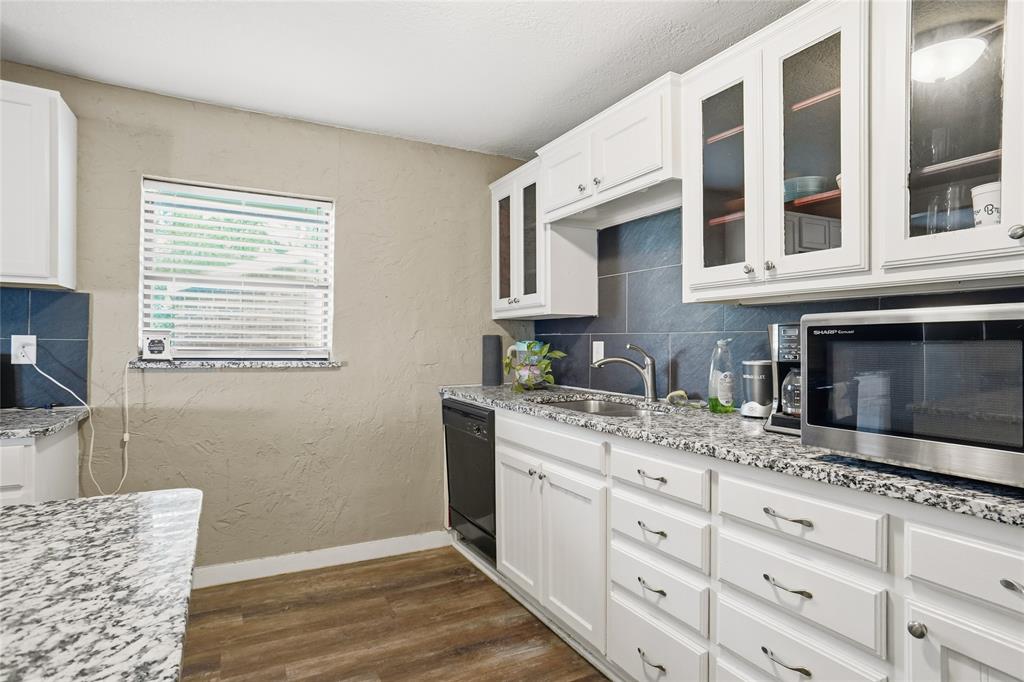 207 School House Road Paradise, TX 76073 - Photo 13 of 33 a kitchen with stainless steel appliances granite countertop a stove a sink and a microwave