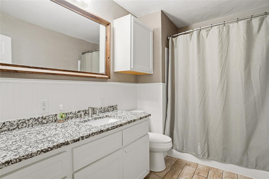 207 School House Road Paradise, TX 76073 - Photo 17 of 33 a bathroom with a granite countertop sink and a mirror