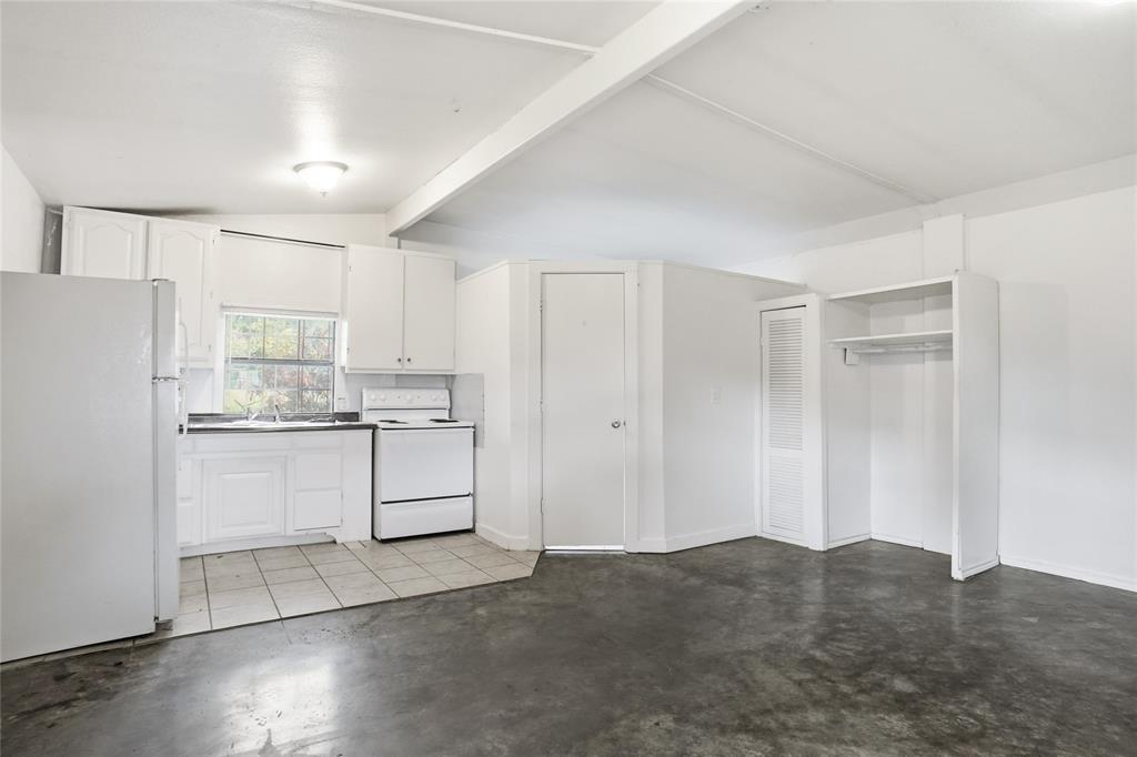 207 School House Road Paradise, TX 76073 - Photo 25 of 33 a kitchen with white cabinets and white appliances