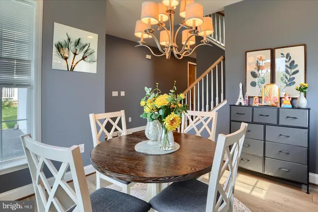 a view of a dining room with furniture a chandelier and wooden floor
