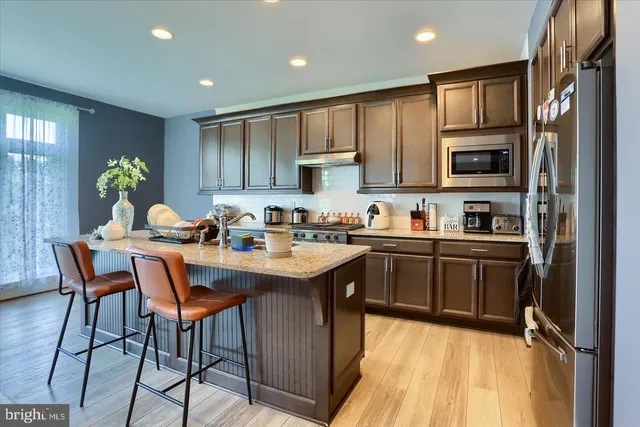 a kitchen with a sink refrigerator and cabinets
