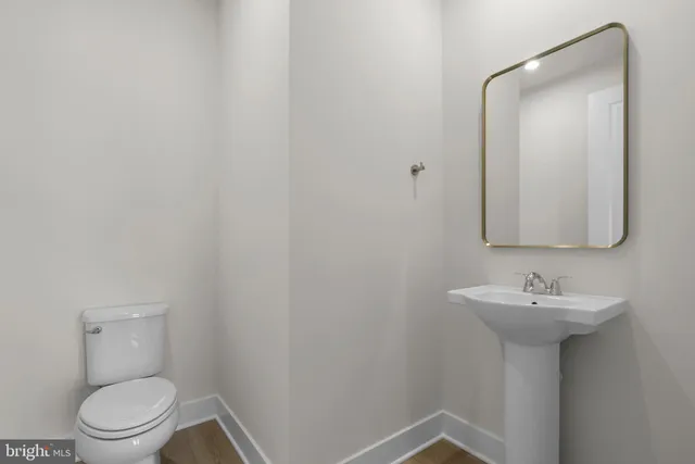 a bathroom with a sink toilet and mirror