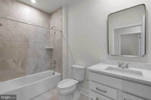 a bathroom with a granite countertop sink a toilet and bathtub