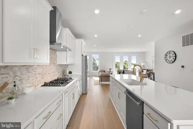 a kitchen with stainless steel appliances a sink stove and cabinets