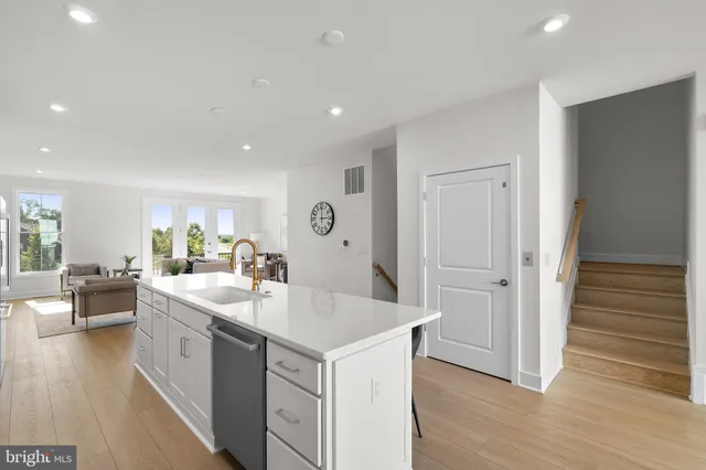 a kitchen with a sink and wooden floor