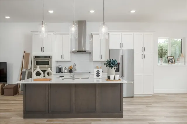 a large white kitchen with lots of counter space and refrigerator