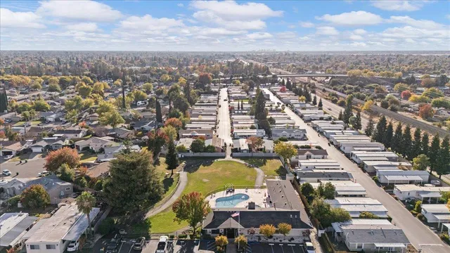 an aerial view of a city with lots of residential buildings ocean and mountain view in back