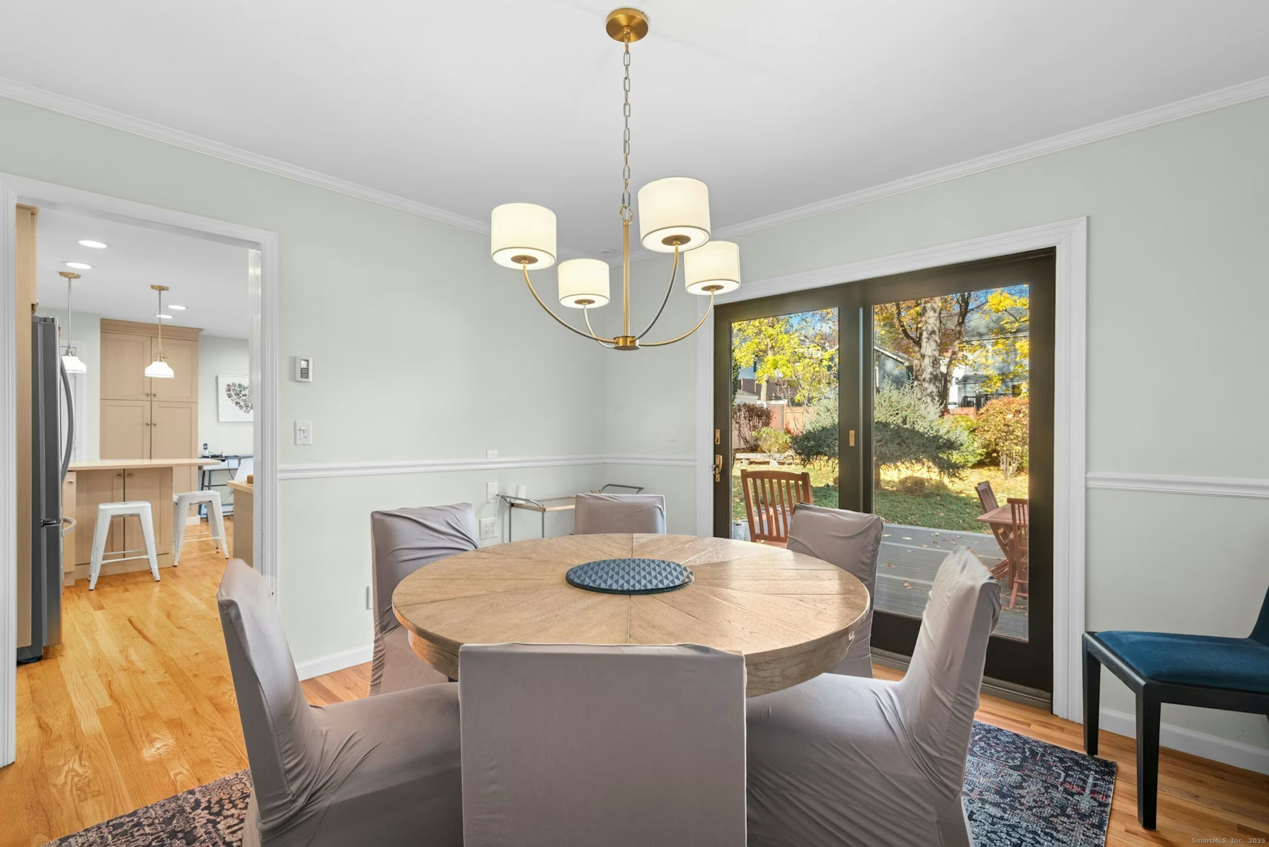 85 Hirsch Road Stamford, CT 06905 - Photo 11 of 27 a dining room with wooden floor a chandelier a glass table and chairs