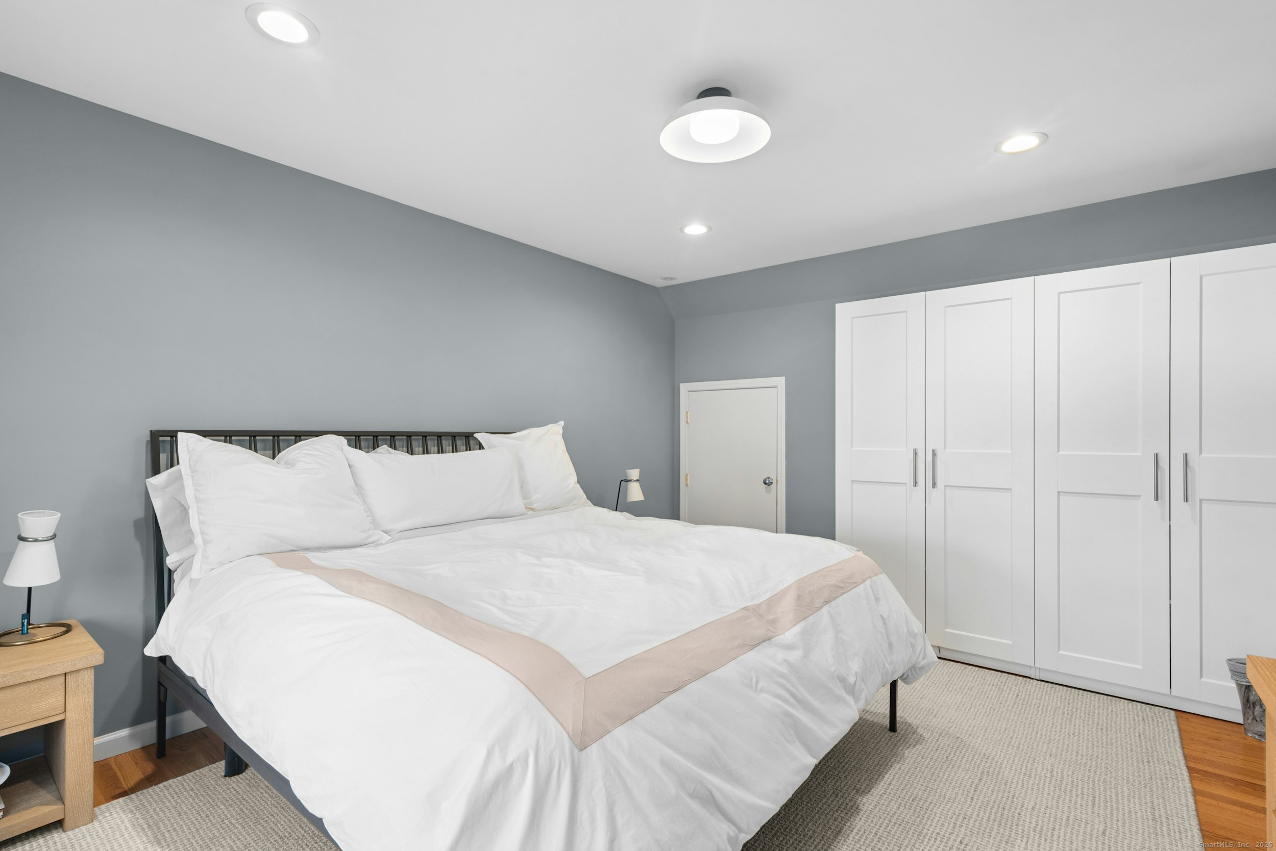 85 Hirsch Road Stamford, CT 06905 - Photo 16 of 27 a bedroom with a large bed and a chandelier