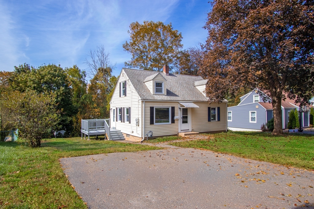 a front view of a house with a garden and trees