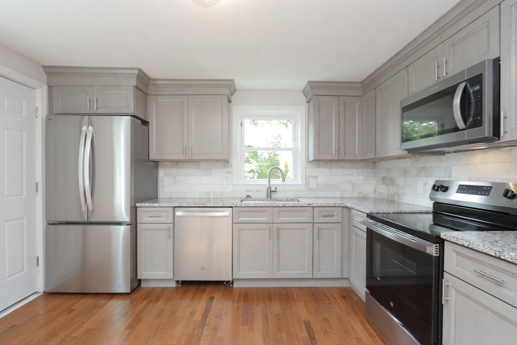 32 Lotus Street West Springfield, MA 01089 - Photo 3 of 42 a kitchen with a sink a microwave a refrigerator and cabinets