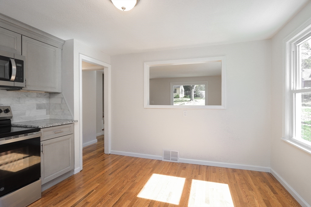 32 Lotus Street West Springfield, MA 01089 - Photo 7 of 42 a view of a kitchen with wooden floor and a fireplace