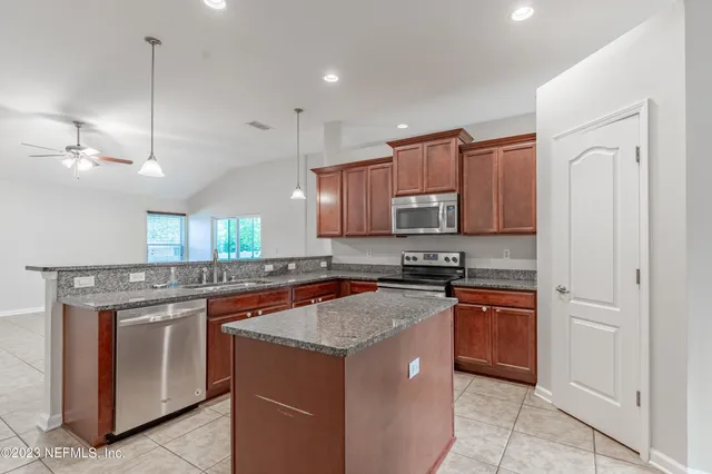 a kitchen with stainless steel appliances granite countertop a stove a sink and a refrigerator