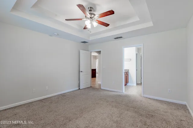an empty room with ceiling fan and closet
