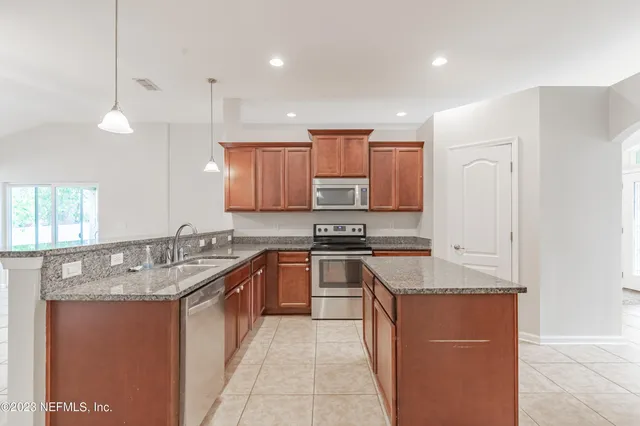 a kitchen with stainless steel appliances granite countertop a sink stove and refrigerator