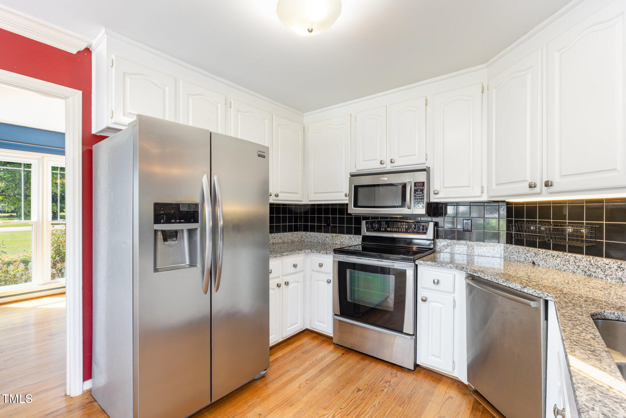 823 Shadow Lake Drive Willow Spring, NC 27592 - Photo 13 of 31 a kitchen with stainless steel appliances granite countertop a refrigerator a stove and a sink with wooden floor