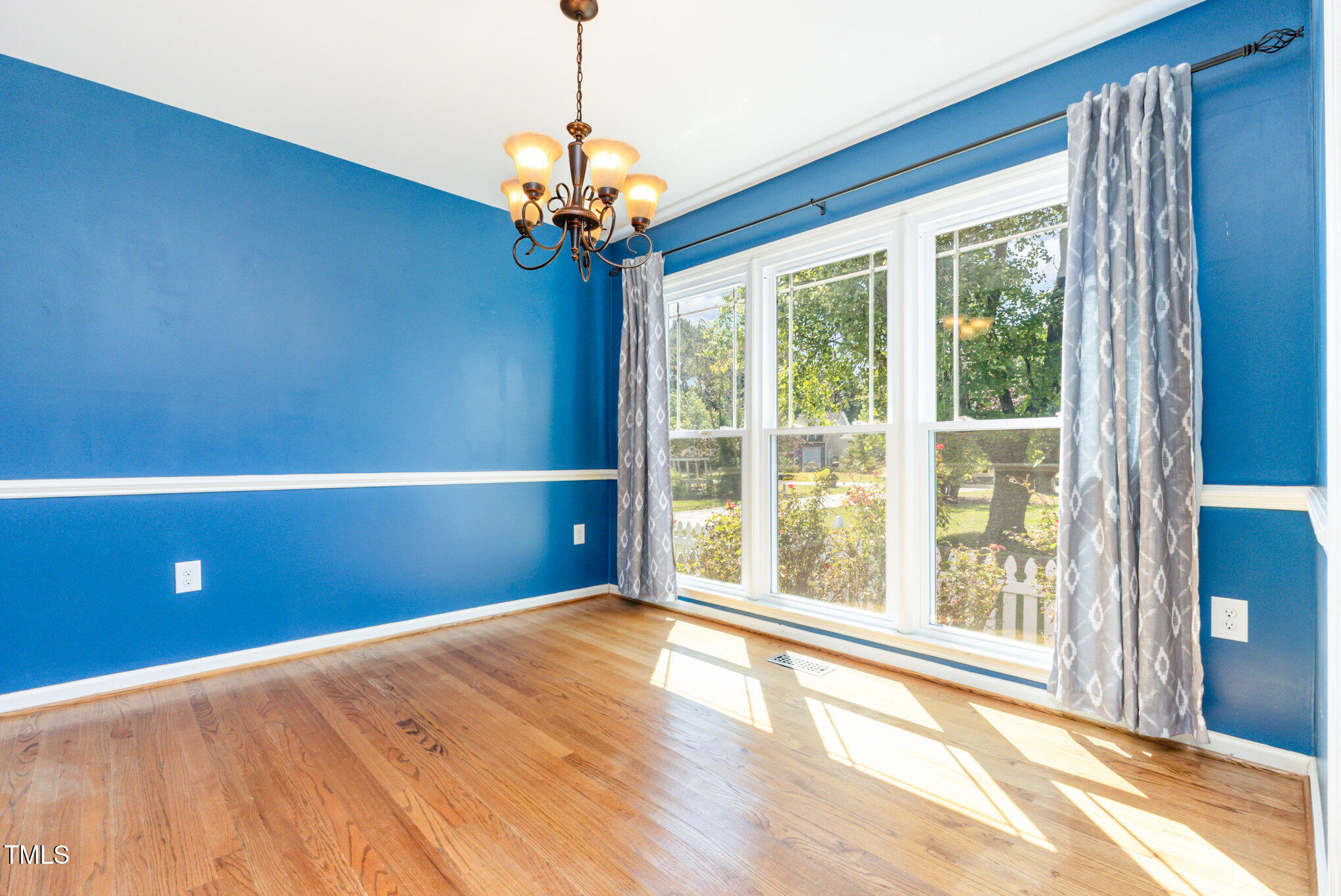 823 Shadow Lake Drive Willow Spring, NC 27592 - Photo 6 of 31 a view of an empty room with a window and wooden floor
