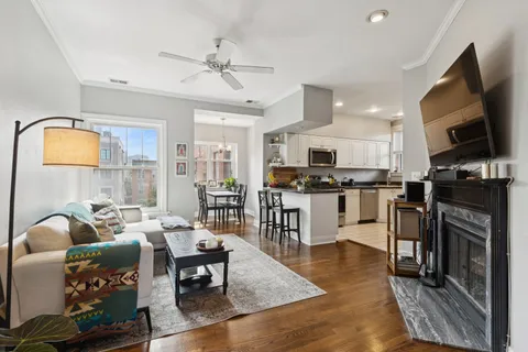 a living room with stainless steel appliances furniture and a kitchen view